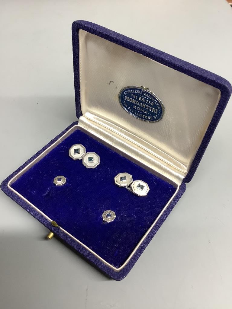 A cased four piece white metal (stamped 750) and sapphire set octagonal dress stud set, comprising a pair of cufflinks and two studs